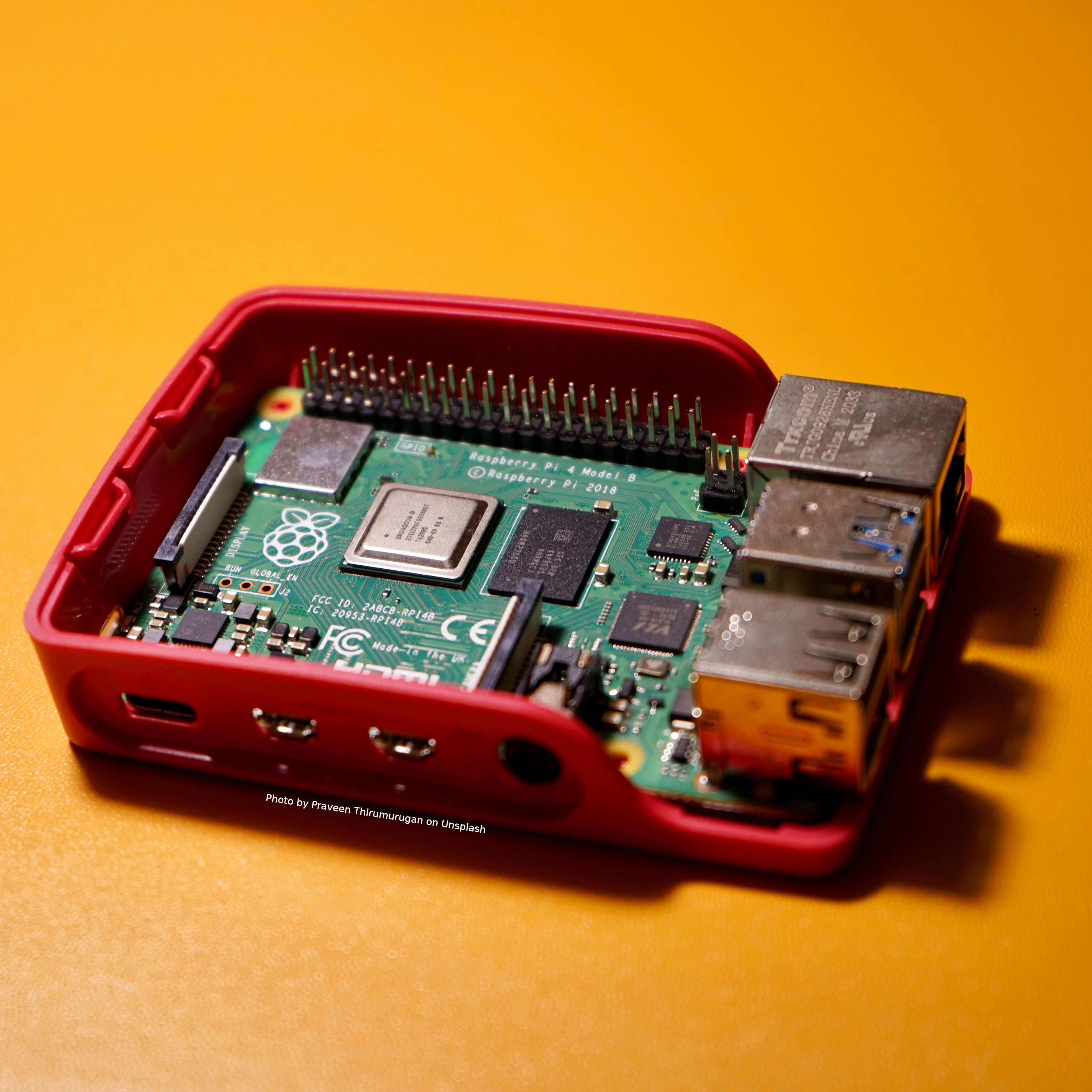 Project Tutorial. Headless Raspberry Pi Interactive. Image: An open cased Raspberry Pi computer on an oranger background